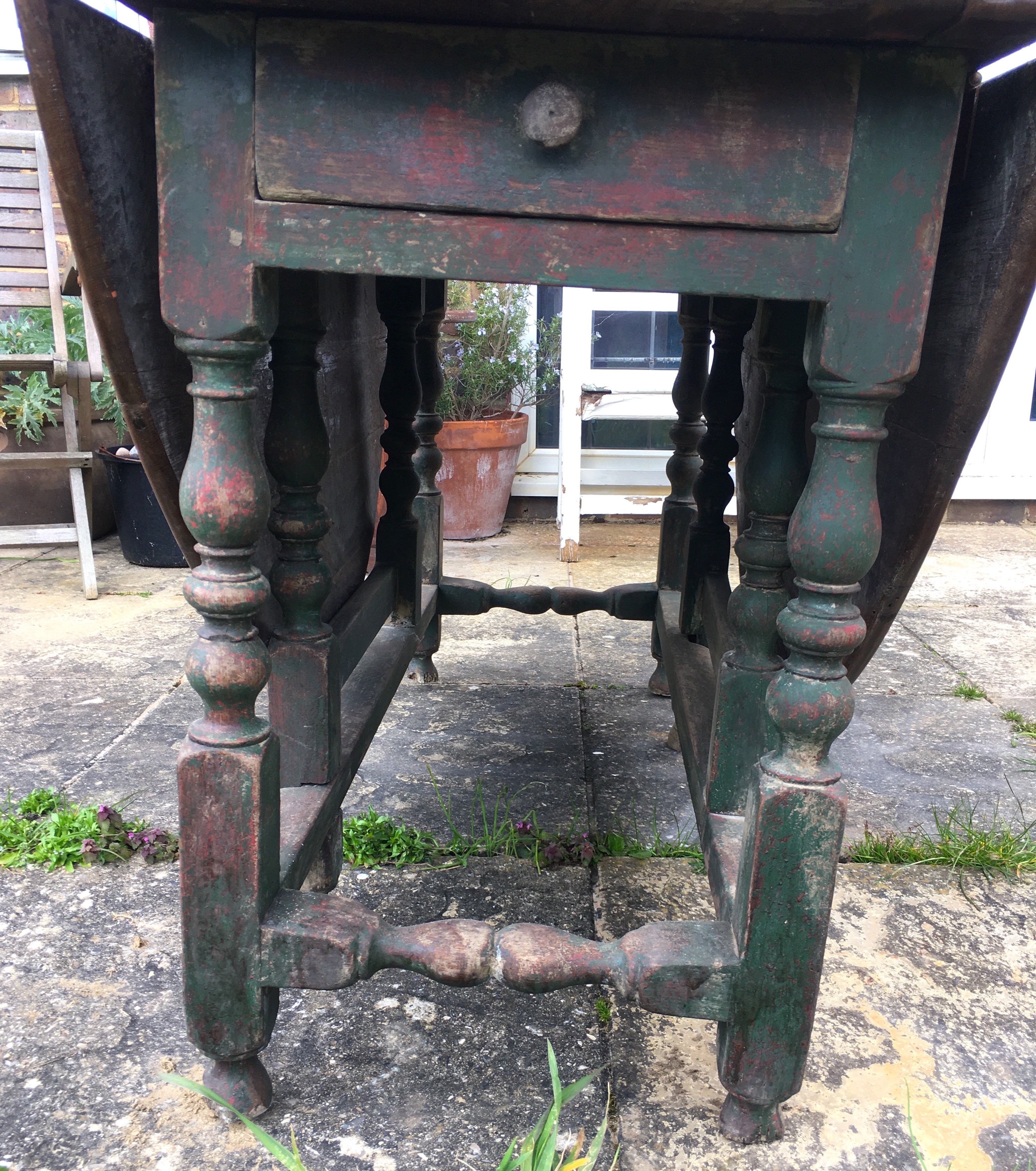 An 18th century oak gateleg dining table, the turned underframe with traces of old paint, length 123cm, depth extended 134cm, height 72cm *Please note the sale commences at 9am.
